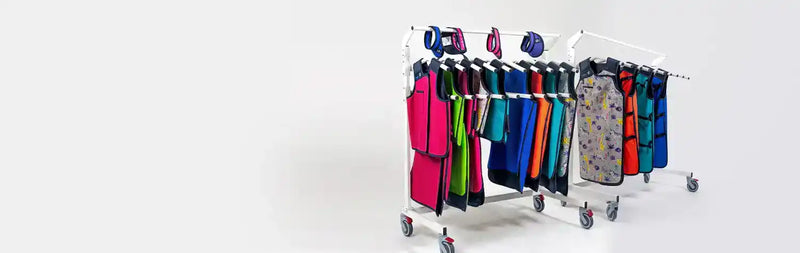 Two lead apron racks with wheels, with lead aprons and bib thyroid collars hanging tidily from them