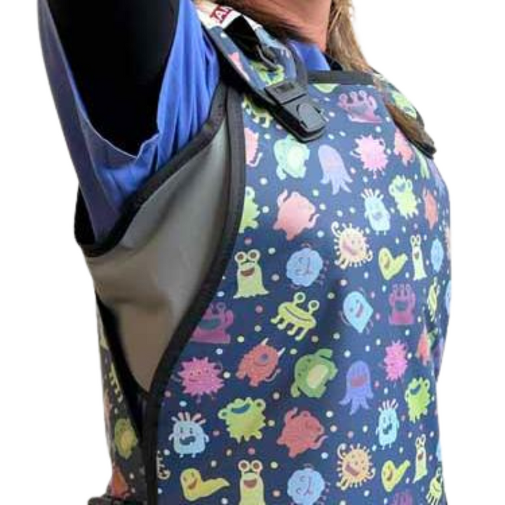 Person wearing a blue scrub top with the Mammoshield - shoulder brace - under the apron on a white background